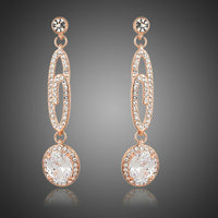 KHAISTA lightweight dangling G-shape drop earrings on white background