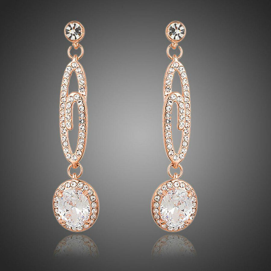 KHAISTA lightweight dangling G-shape drop earrings on white background