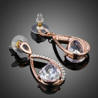 Close up of KHAISTA gold plated CZ drop earrings