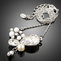 Side angle view of KHAISTA long chain pearl pendant necklace