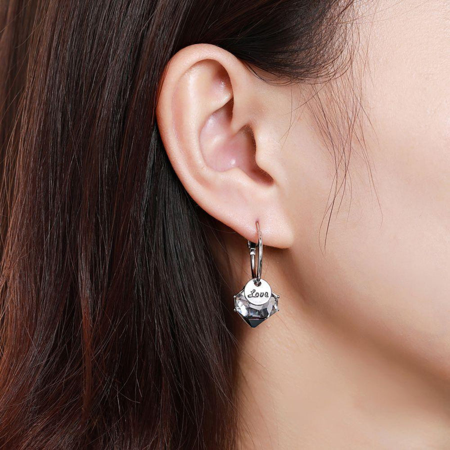 KHAISTA love crystal drop earrings on white background