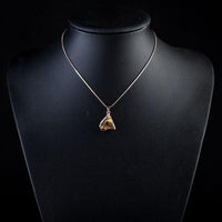 Side angle view of KHAISTA love triangle champagne crystal necklace
