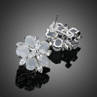 Close up of KHAISTA milky white CZ flower clip earrings