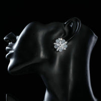 Side angle view of KHAISTA milky white CZ flower clip earrings