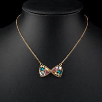 Close up detail of KHAISTA multicolour crystal bow knot necklace