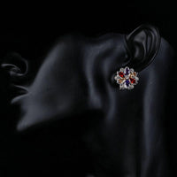 Side angle view of KHAISTA multicoloured flower stud earrings