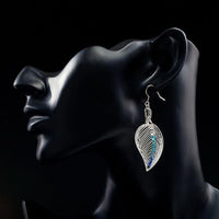 Close up of KHAISTA multicolour crystal leaf drop earrings