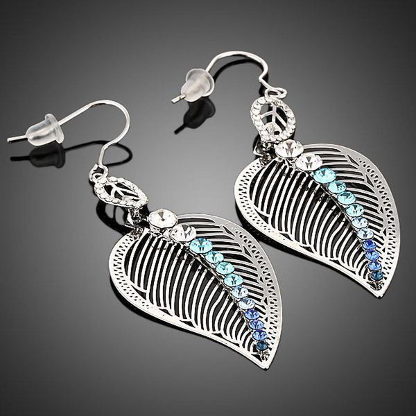 KHAISTA multicolour crystal leaf drop earrings on white background