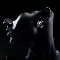 Side angle view of KHAISTA ocean blue crystal clip earrings