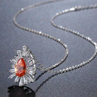 Close up detail of KHAISTA orange CZ chain pendant necklace