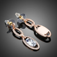 Close up of KHAISTA oval chain link crystal drop earrings