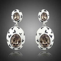 KHAISTA oval crystal pave drop earrings on white background