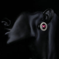 Side angle view of KHAISTA oval maroon CZ stud earrings