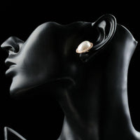 Close up of KHAISTA oval shell pearl stud earrings