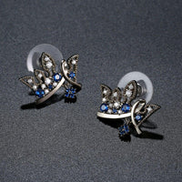 Side angle view of KHAISTA paved blue CZ crown stud earrings