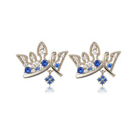 Close up of KHAISTA paved blue CZ crown stud earrings