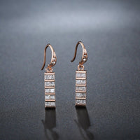 Side angle view of KHAISTA paved square cut rectangle drop earrings