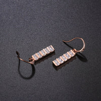 Close up of KHAISTA paved square cut rectangle drop earrings
