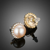 Close up of KHAISTA peach pearl dome stud earrings