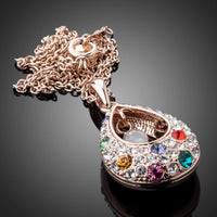 Side angle view of KHAISTA peacock tears crystal pendant necklace