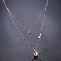 Side angle view of KHAISTA clear pear cut CZ necklace