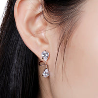 Close up of KHAISTA pear cut CZ drop earrings