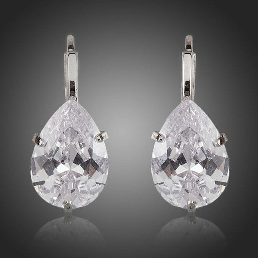 KHAISTA pear shaped CZ drop earrings on white background
