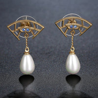 Side angle view of KHAISTA pearl cubic zirconia drop earrings
