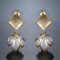 Side angle view of KHAISTA pearl drop earrings for women