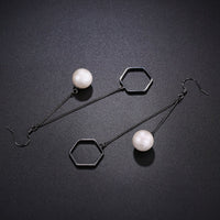 Close up of KHAISTA classic pearl drop earrings
