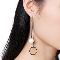 Side angle view of KHAISTA classic pearl drop earrings