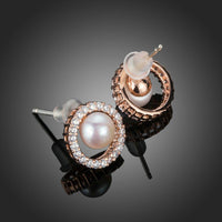 Side angle view of KHAISTA pearl eyeball stud earrings