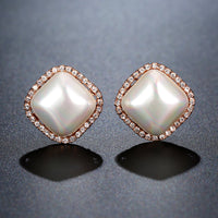 Side angle view of KHAISTA pearl geometric stud earrings