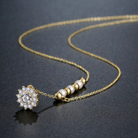 Close up detail of KHAISTA pearl sunflower pendant necklace