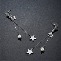 Close up of KHAISTA clear CZ pearl pentagram drop earrings