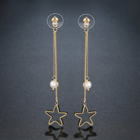 Close up of KHAISTA pentagram crystal drop earrings
