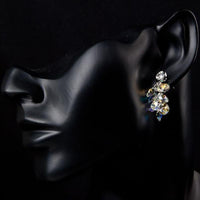 Side angle view of KHAISTA platinum plated crystal cluster drop earrings