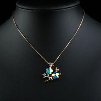 Close up detail of KHAISTA plum blossom branch pendant necklace