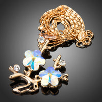 Side angle view of KHAISTA plum blossom branch pendant necklace