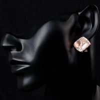 Side angle view of KHAISTA popping eyes emoji crystal stud earrings