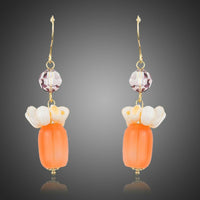 KHAISTA pumpkin orange crystal drop earrings on white background