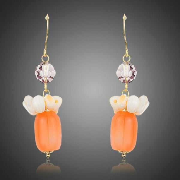 KHAISTA pumpkin orange crystal drop earrings on white background