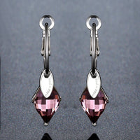 Side angle view of KHAISTA purple Austrian crystal drop earrings