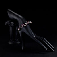 Side angle view of KHAISTA purple blossom twig bangle