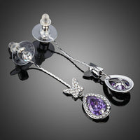 Close up of KHAISTA purple butterfly zirconia drop earrings