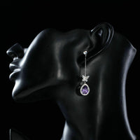 Side angle view of KHAISTA purple butterfly zirconia drop earrings