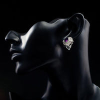 Side angle view of KHAISTA purple crystal dome stud earrings