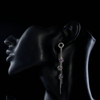 Close up of KHAISTA purple CZ drop earrings