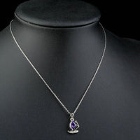Close up detail of KHAISTA purple CZ sail boat necklace