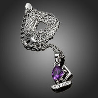 Side angle view of KHAISTA purple CZ sail boat necklace